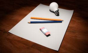 Blank paper with pencils, eraser and a light bulb.