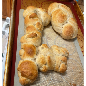 Two baked challah breads on a tray, one in the shape of an old-fashioned key