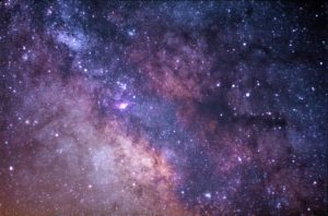 Black and purple background, stars and cloudy galaxies.