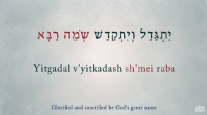 Grey background, first line of the Mourner's Kaddish in Aramaic, transliteration and translation.